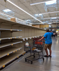 Man surveying empty store shelves