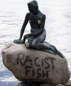 Little Mermaid statue in Copenhagen, with "RACIST FISH" scrawled below