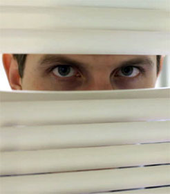 Man peeking through blinds