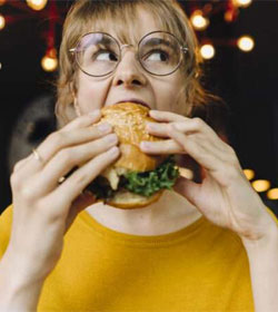 Worried woman eating a hamburger